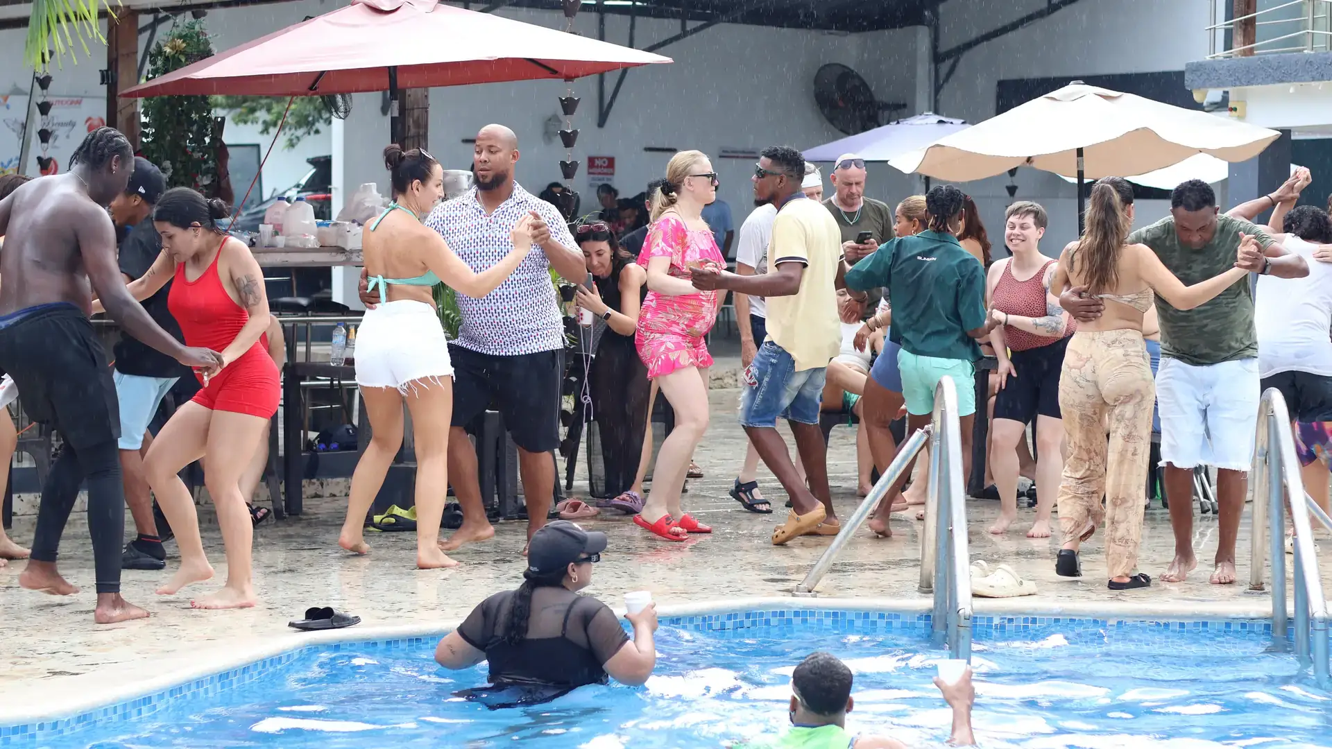Locals and travelers dancing bachata together at a pool party in the Dominican Republic